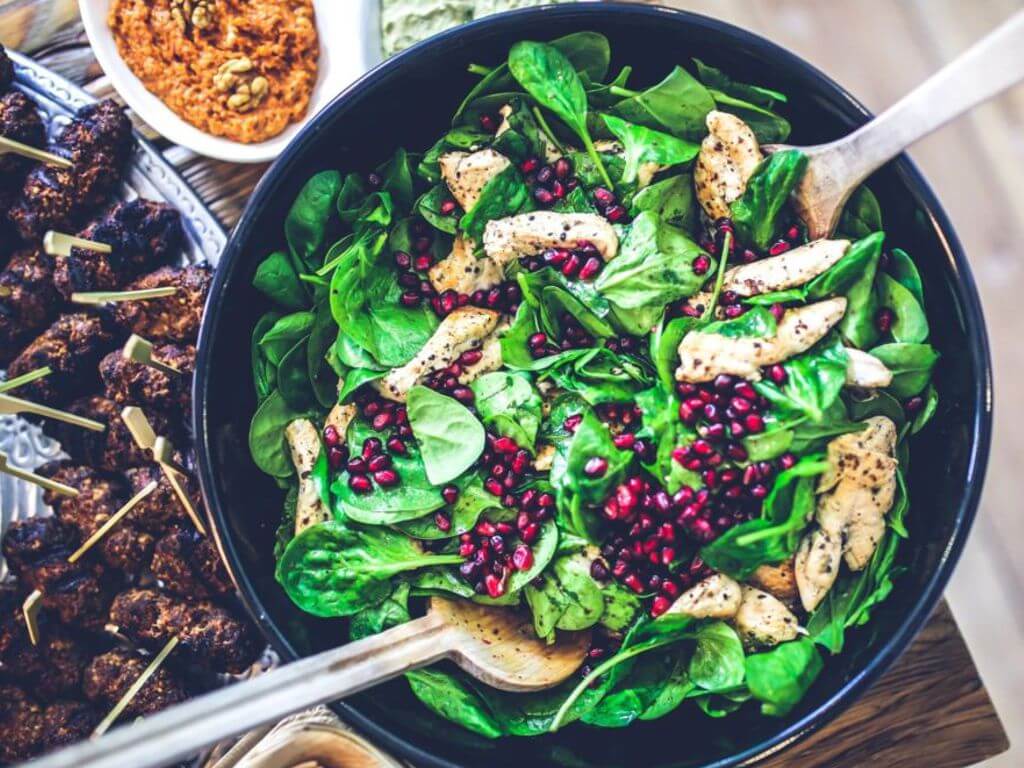 Σκεύος με πράσινη σαλάτα, σπόρους ροδιού και Σπιρουλίνα flakes