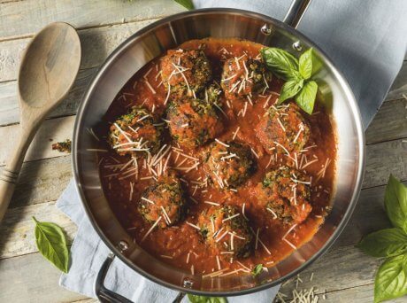 Μεταλλικό σκεύος με σουτζουκάκια με κόκκινη σάλτσα και φύλλα δυόσμου για διακόσμηση