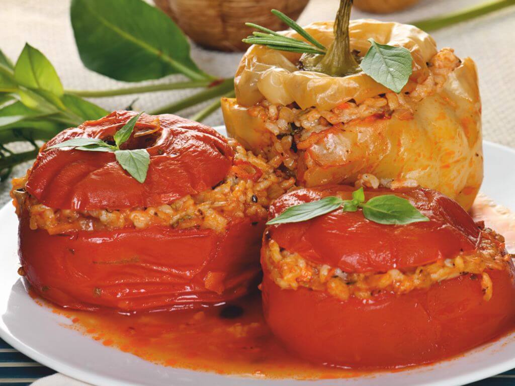 Πιάτο με δύο ντομάτες και μία πιπεριά πράσινη γεμισμένα με ρύζι και τραχανά