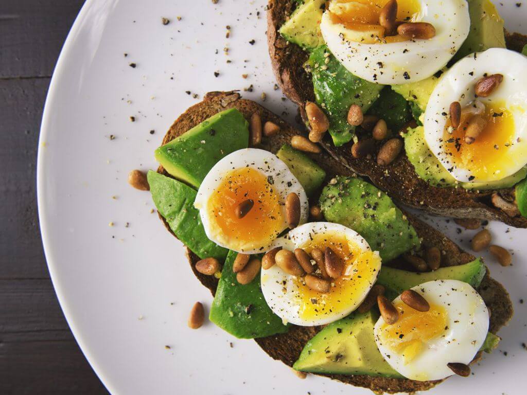 Πιάτο με ανοιχτό τοστ με αβοκάντο, αυγό και Σπιρουλίνα flakes