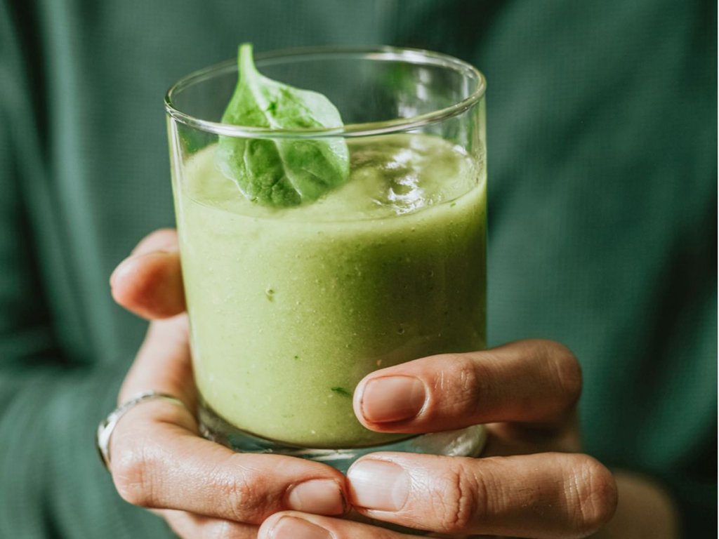 Ποτήρι με πράσινο smoothie με ένα φύλλο δυόσμο