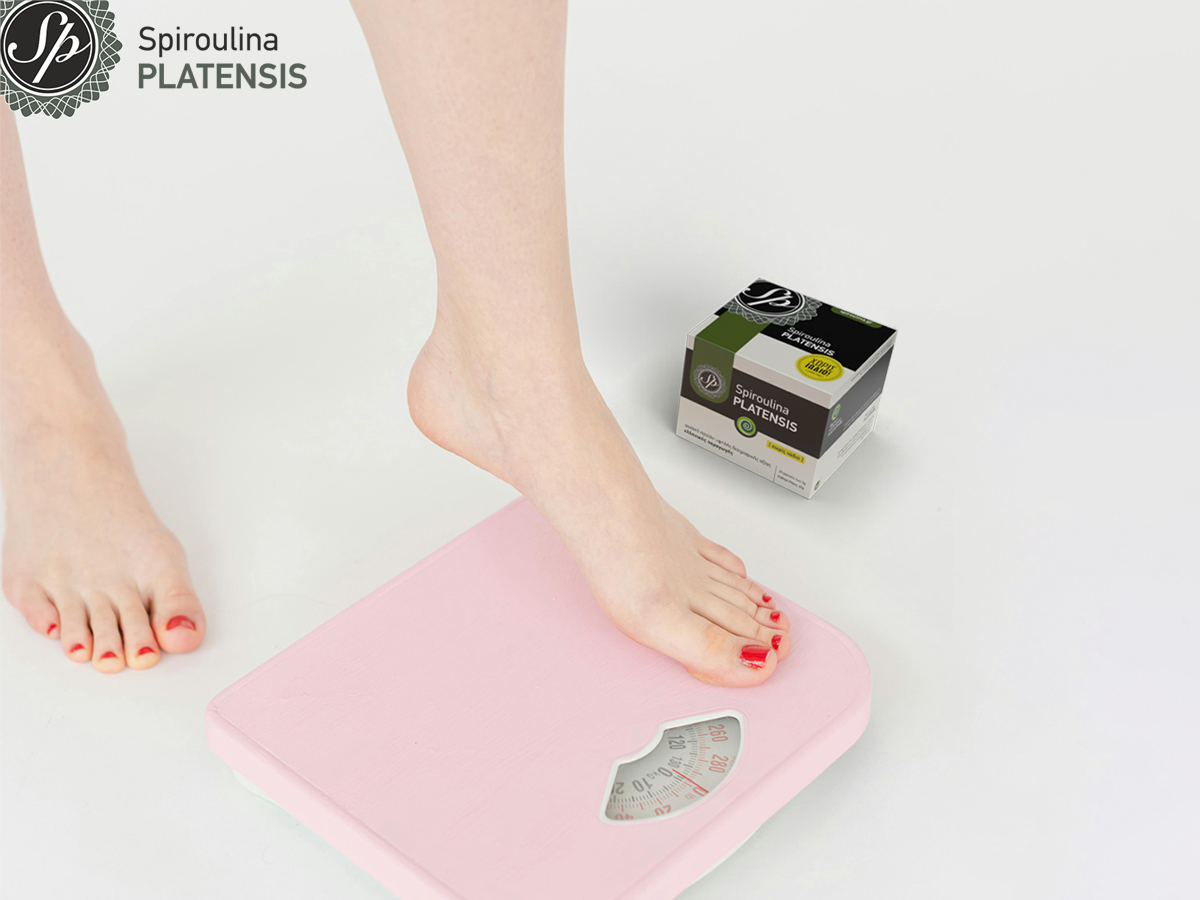 Πόδι σε ζυγαριά δίπλα σε συσκευασία Spiroulina PLATENSIS