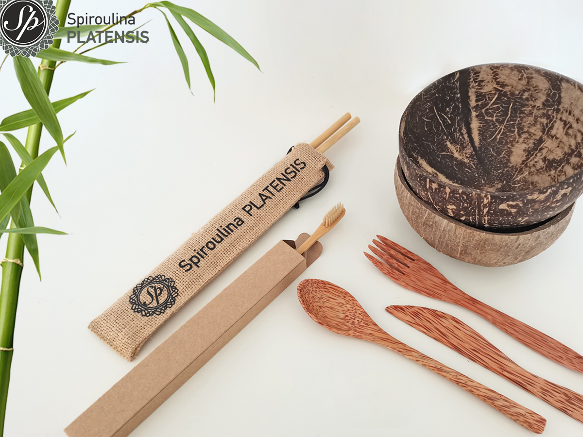 Bamboo καλαμάκια, οδοντόβουρτσα και Coconut bowl & μαχαιροπίρουνα σε λευκή επιφάνεια