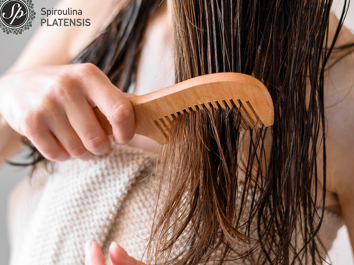 Γυναίκα με καστανά μαλλιά που χτενίζεται