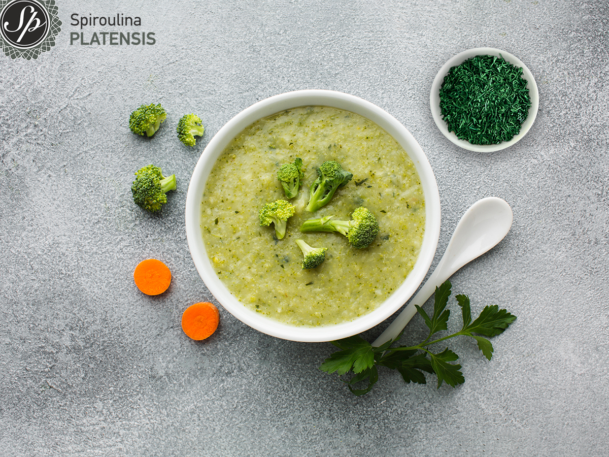 Μπολ με πράσινη σούπα και δίπλα μικρότετο μπολ με Σπιρουλίνα flakes