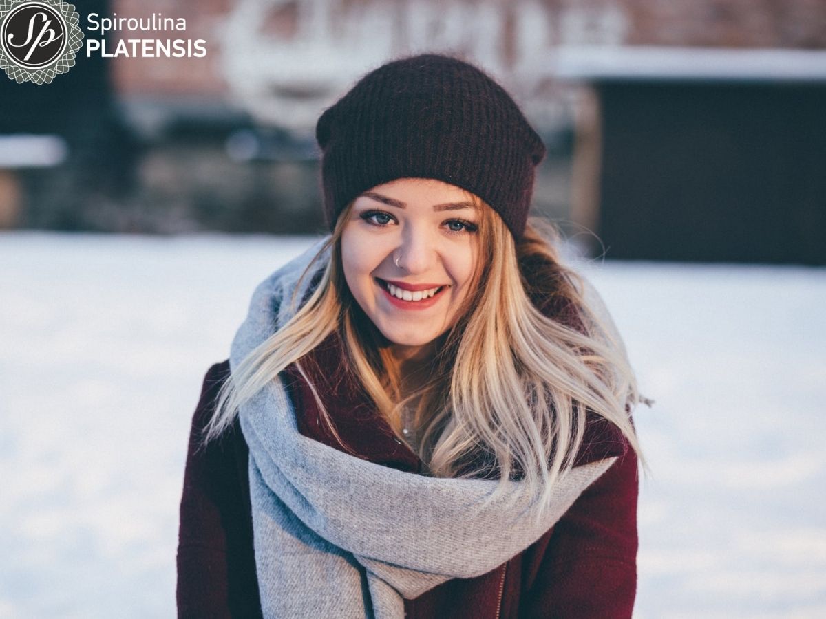 Νεαρή γυναίκα με κασκόλ και σκουφάκι σε εξωτερικό χώρο