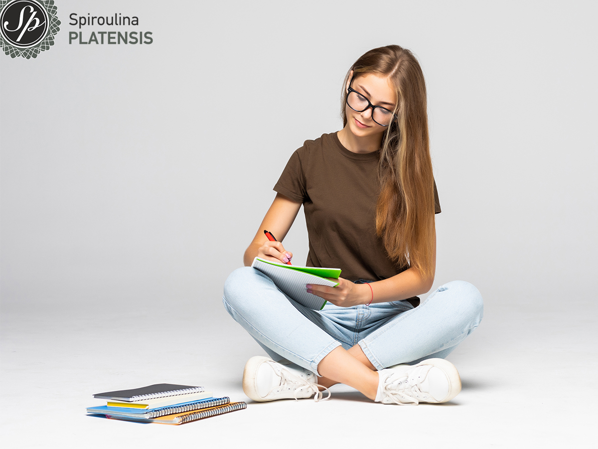 Νεαρή γυναίκα που διαβάζει και κρατάει σημειώσεις
