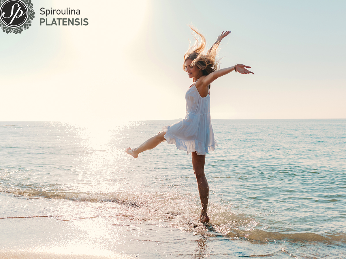 Νεαρή γυναίκα στην παραλία γεμάτη ενέργεια