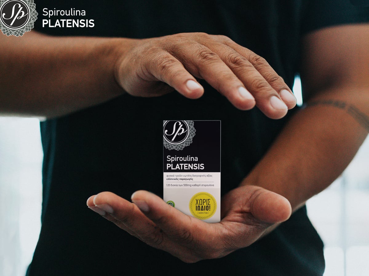 Άνδρας με μαύρο μπλουζάκι που ανάμεσα στα χέρια του έχει τη Spiroulina PLATENSIS χωρίς ιώδιο