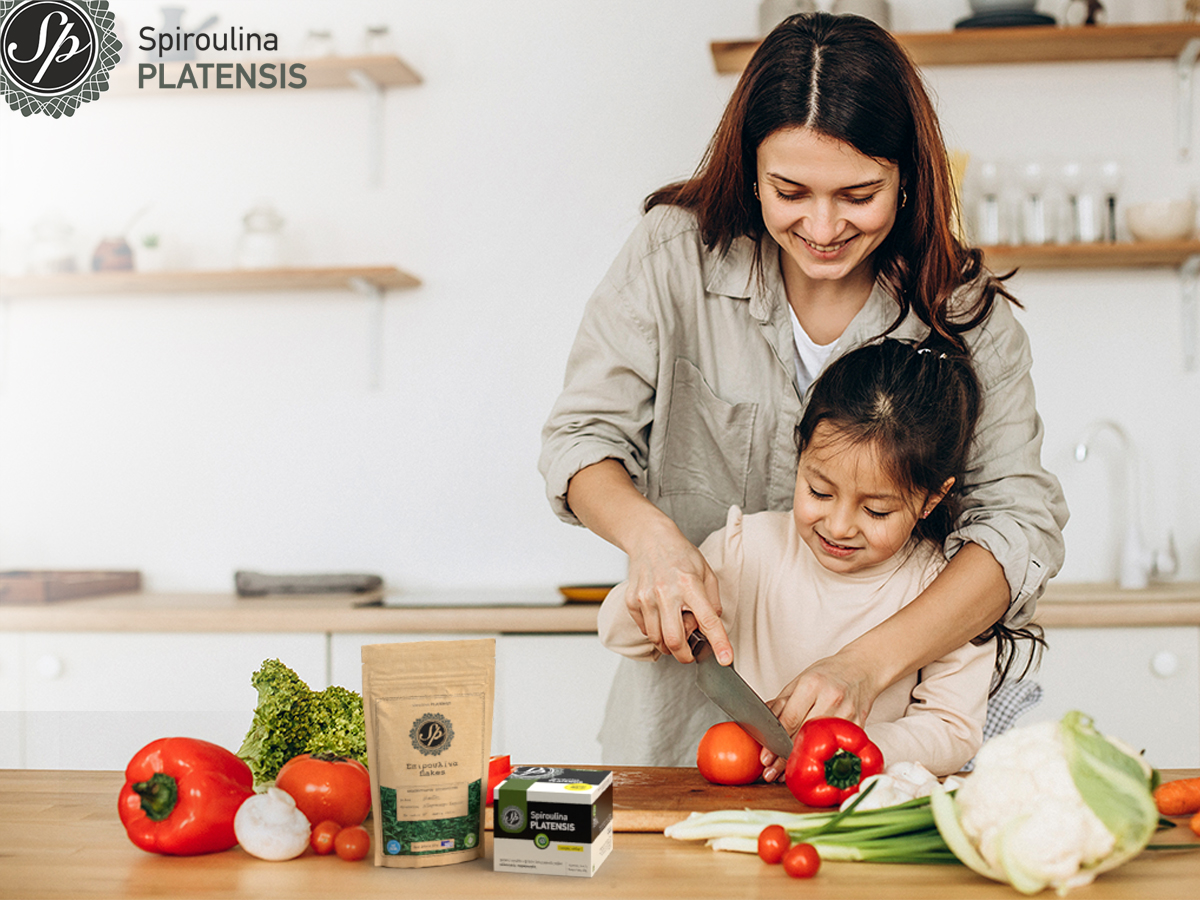 Μαμά και κόρη ετοιμάζουν ένα γεύμα και χρησιμοποιούν spiroulina PLATENSIS