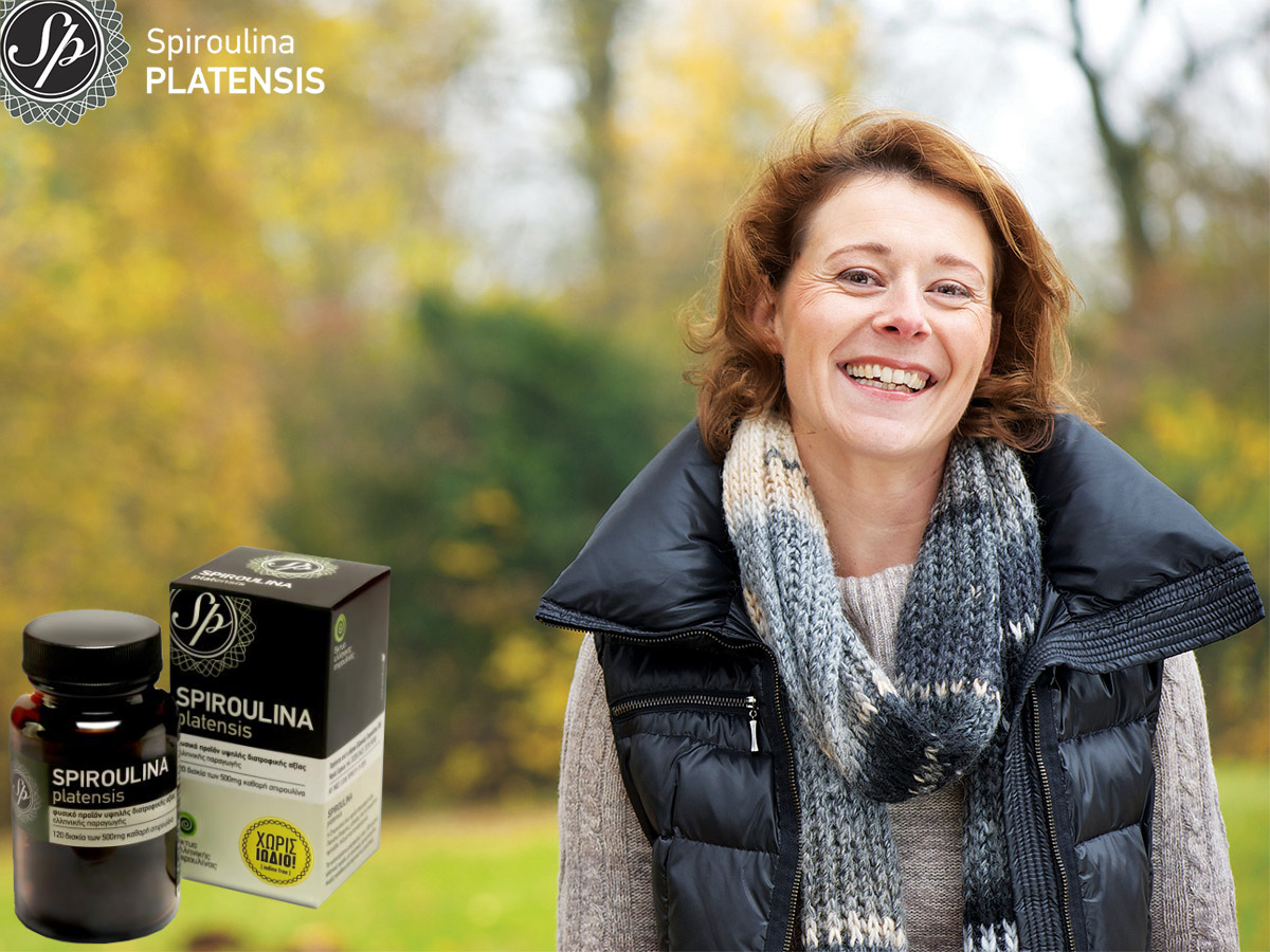 Ώριμη γυναίκα σε εξωτερικό φθινοπωρινό σκηνικό χαμογελάει