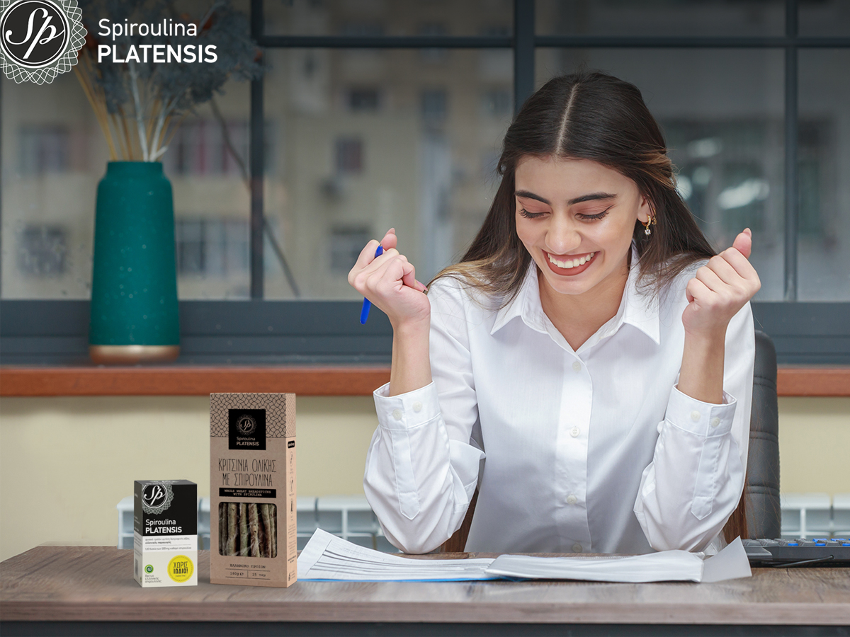 Νεαρή γυναίκα στο γραφείο χαρούμενη και γεμάτη ενέργεια χάρη στη Spiroulina PLATENSIS
