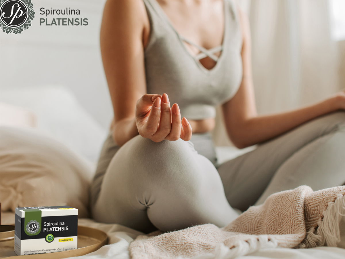 Νεαρή γυναίκα που κάνει yoga & δίπλα έχει μία Spiroulina PLATENSIS