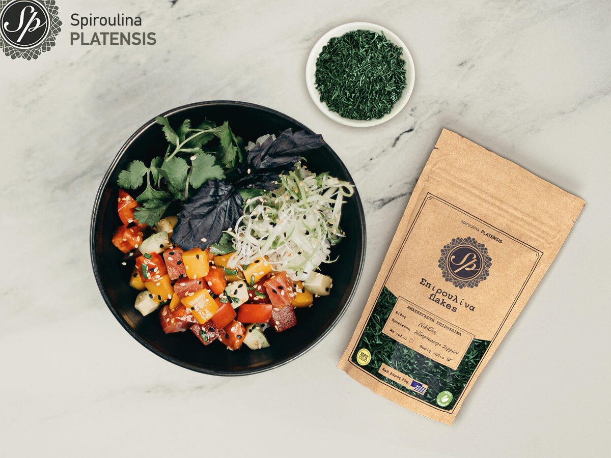 Ένα μπολ με σαλάτα & δίπλα Σπιρουλίνα flakes