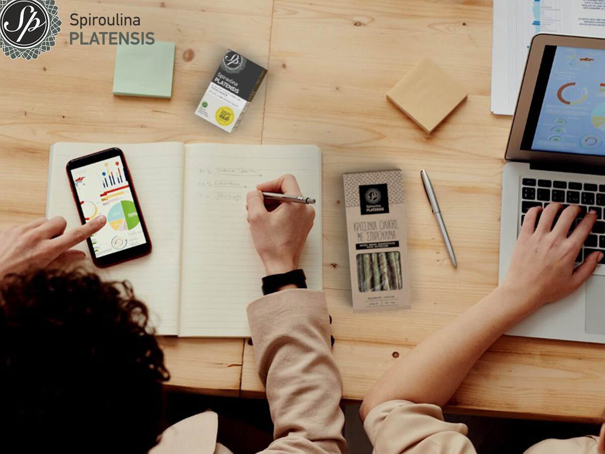 Μία γυναίκα στο γραφείο δουλεύει και έχει δίπλα της Spioroulina PLATENSIS κριτσίνια και ταμπλέτες