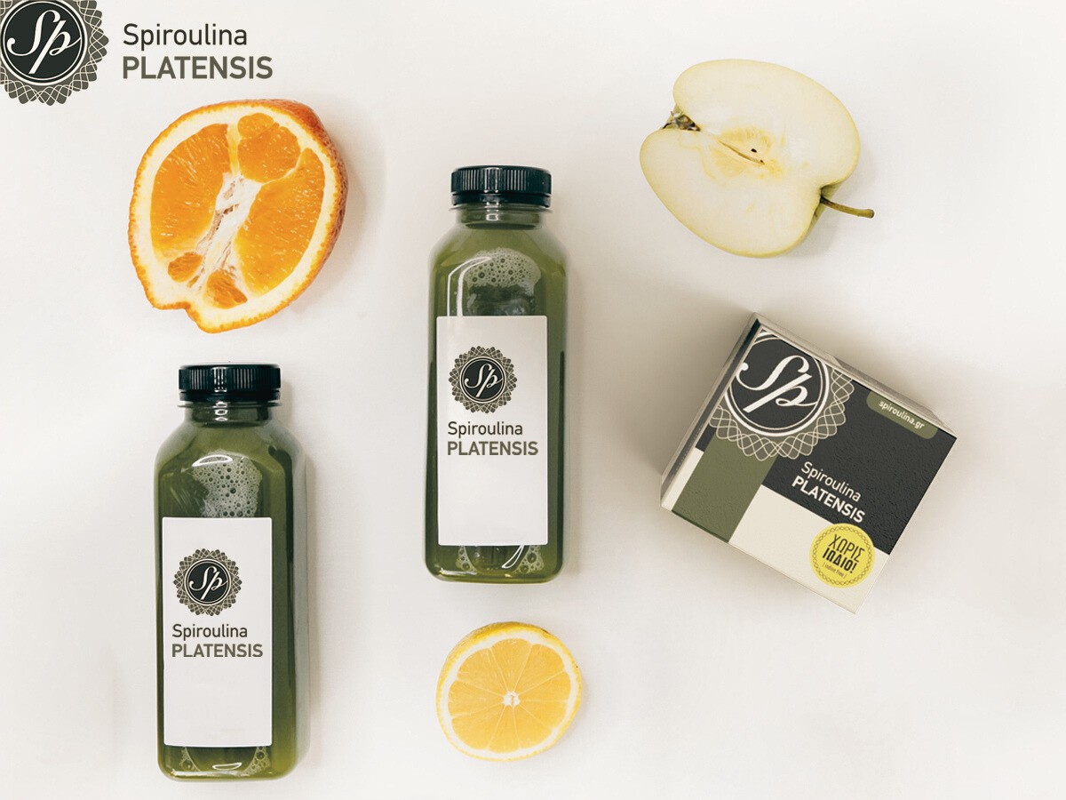 Δύο μπουκαλάκια με πράσινο smoothie & μία συσκευασία Spiroulina PLATENSIS σε σκόνη σε λευκό φόντο