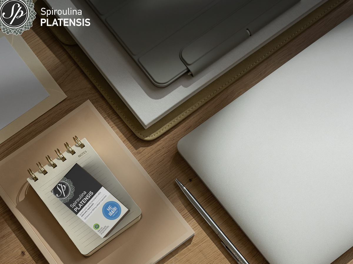 Εργασιακό γραφείο με laptop, σημειωματάριο και συσκευασία Spiroulina PLATENSIS ταμπλέτες με ιώδιο, για άρθρο «your mental booster».